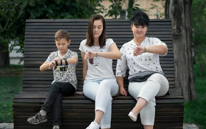 Three people looking at their watches